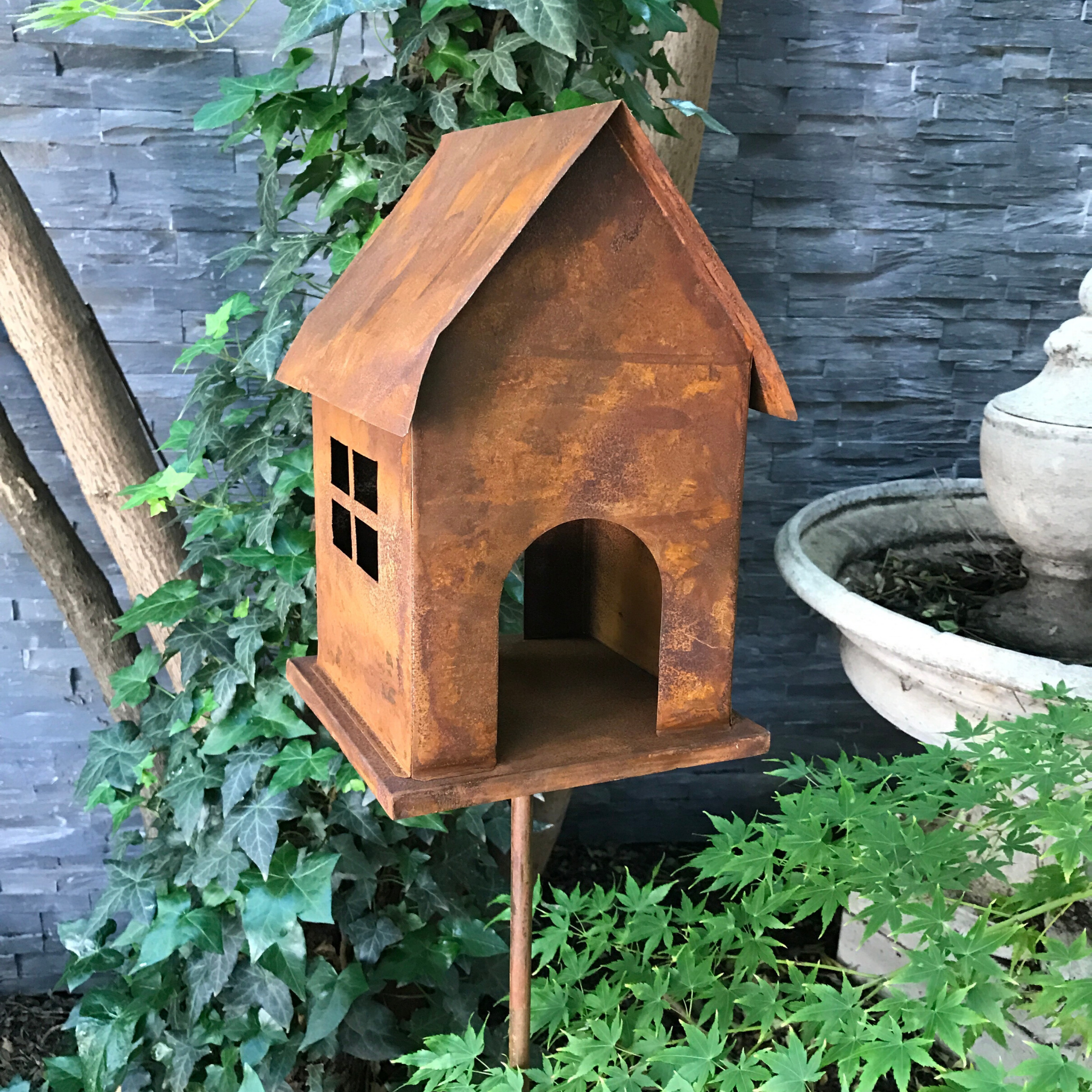 Birdfeeder or birdhouse in rusty metal on a stake fro the garden